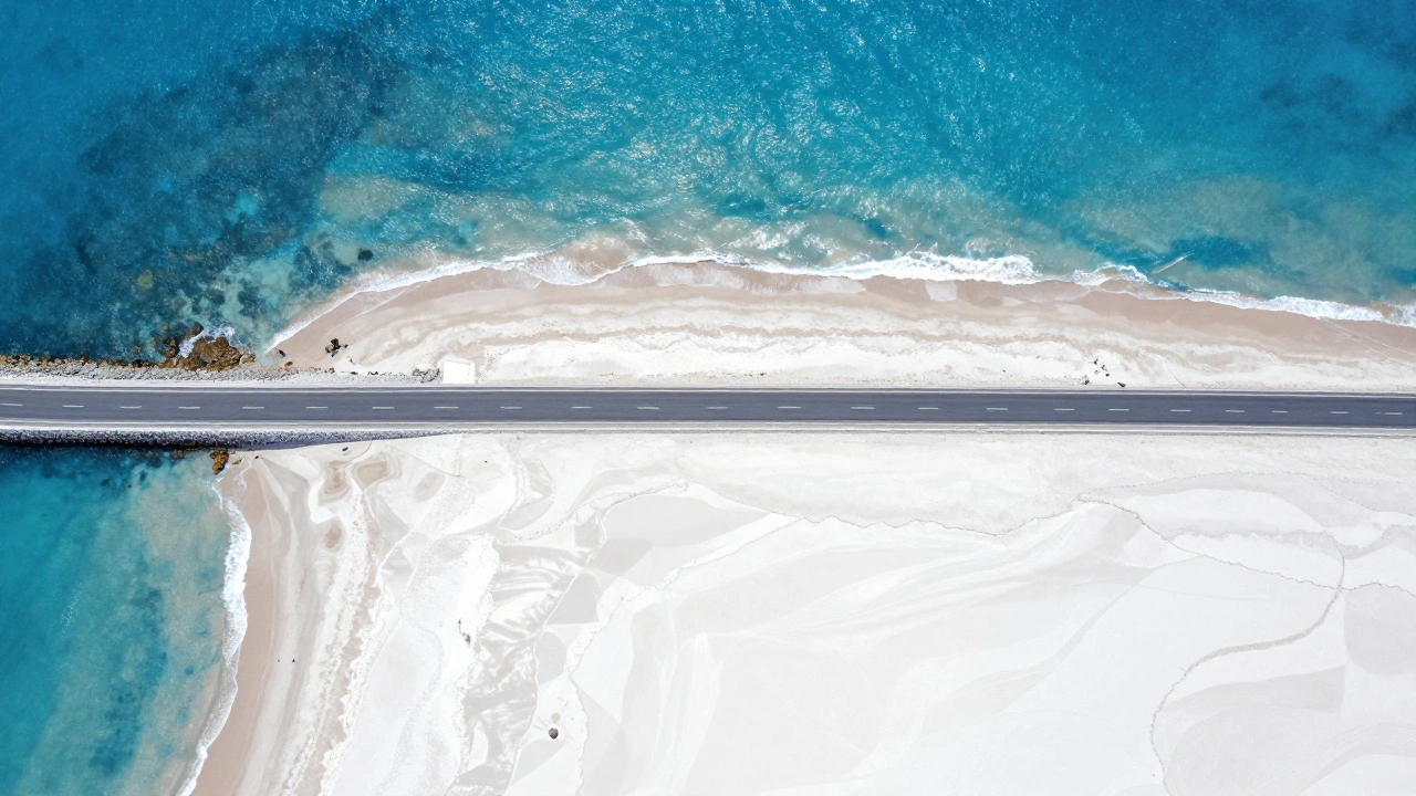 Top-down abstract aerial view of a winding coastal road and turquoise ocean waves
