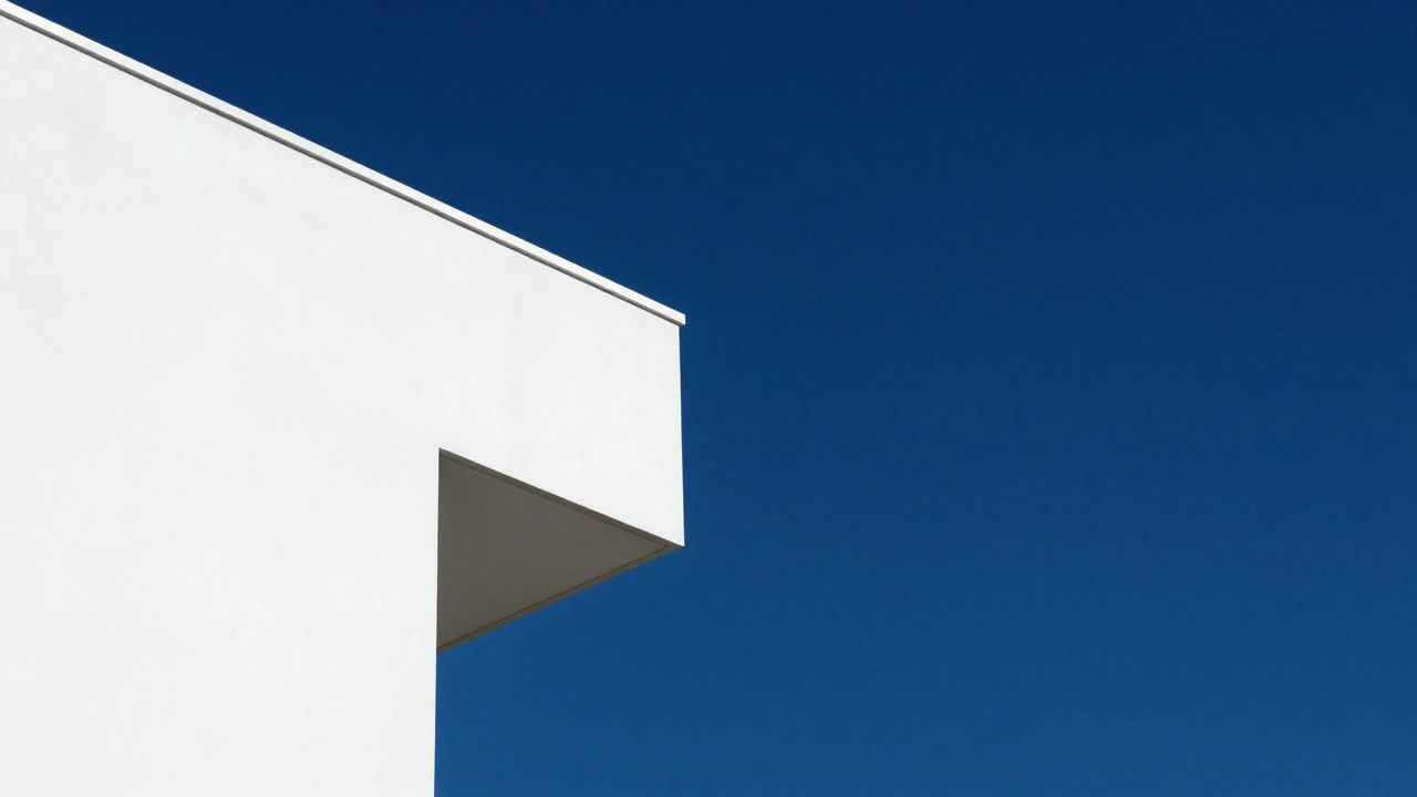 White modern building corner against a deep blue sky creating a geometric shape.