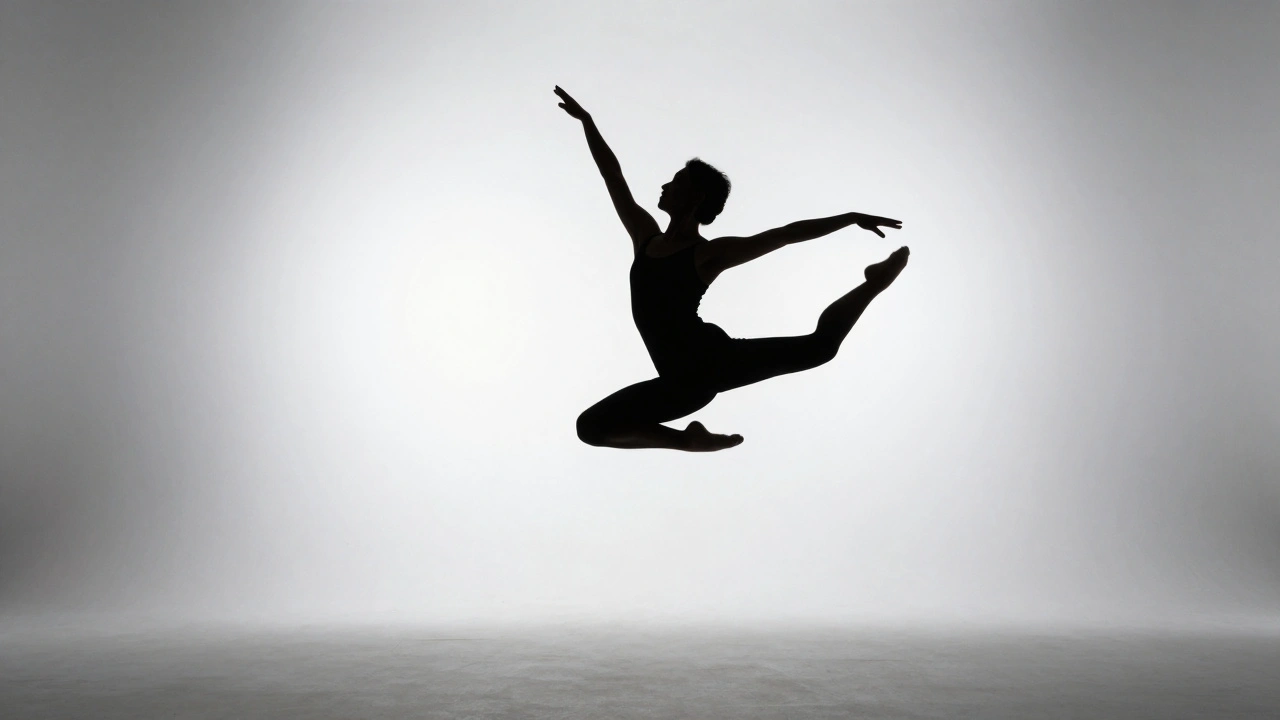 Dancer leaping in black silhouette against a bright white studio background