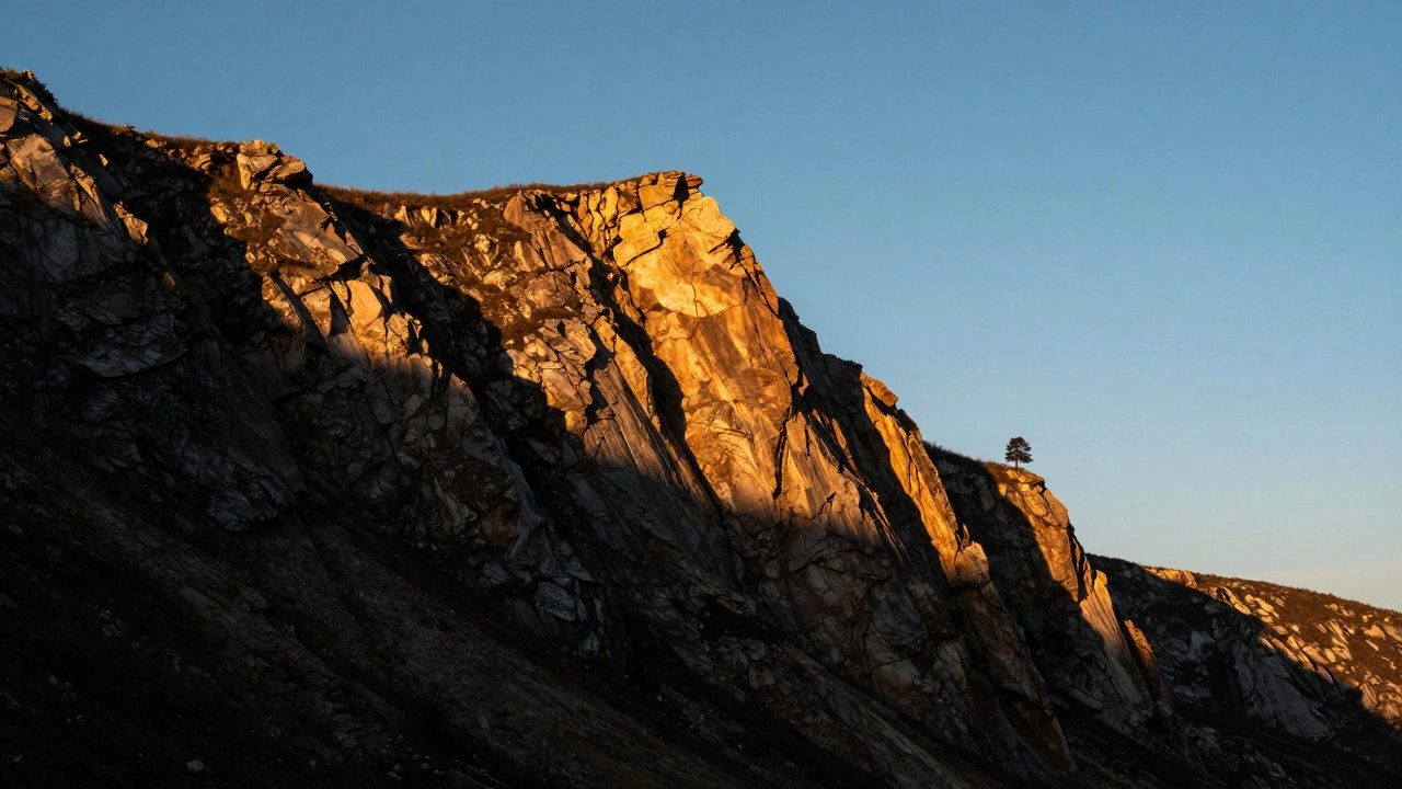 Rugged cliff face at golden hour with strong tonal contrast and silhouetted tree