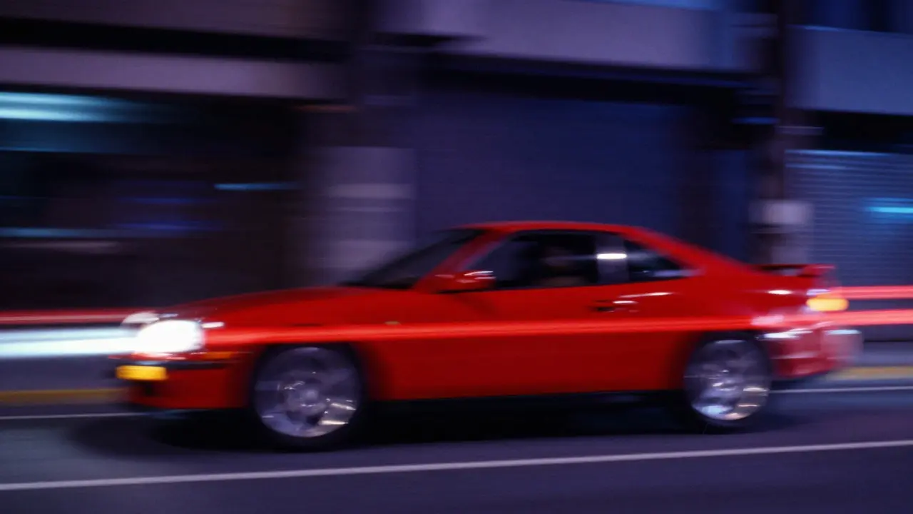 Abstract light trail of a red car demonstrating shutter speed and motion blur concepts