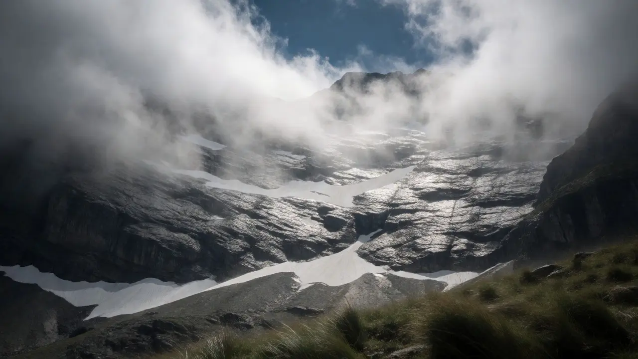 Storm clouds and mist obscuring a textured mountain rock face
