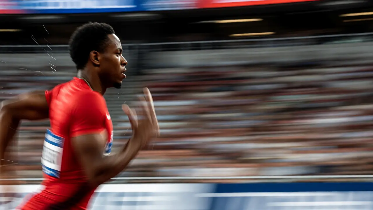 Sharp sprinter running against a horizontally blurred stadium background