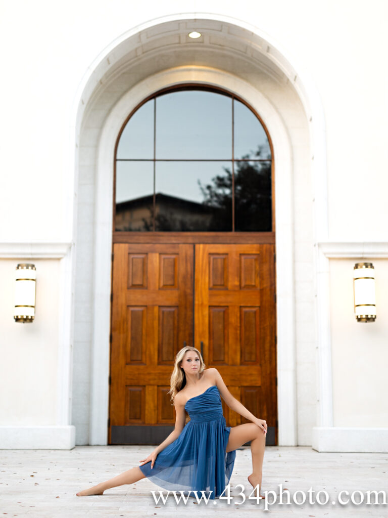 a senior posing in a dance pose in front of a church in winter park florida